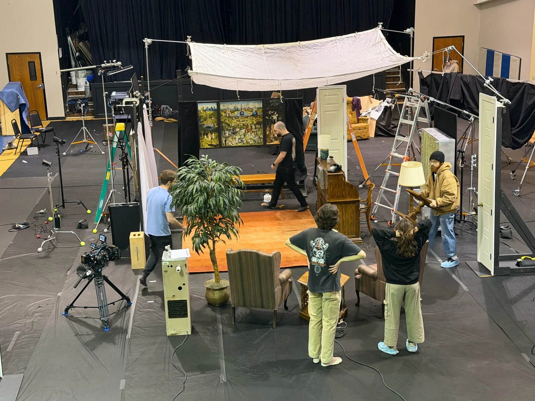 A wide view reveals the studio, handmade set, and lighting equipment.